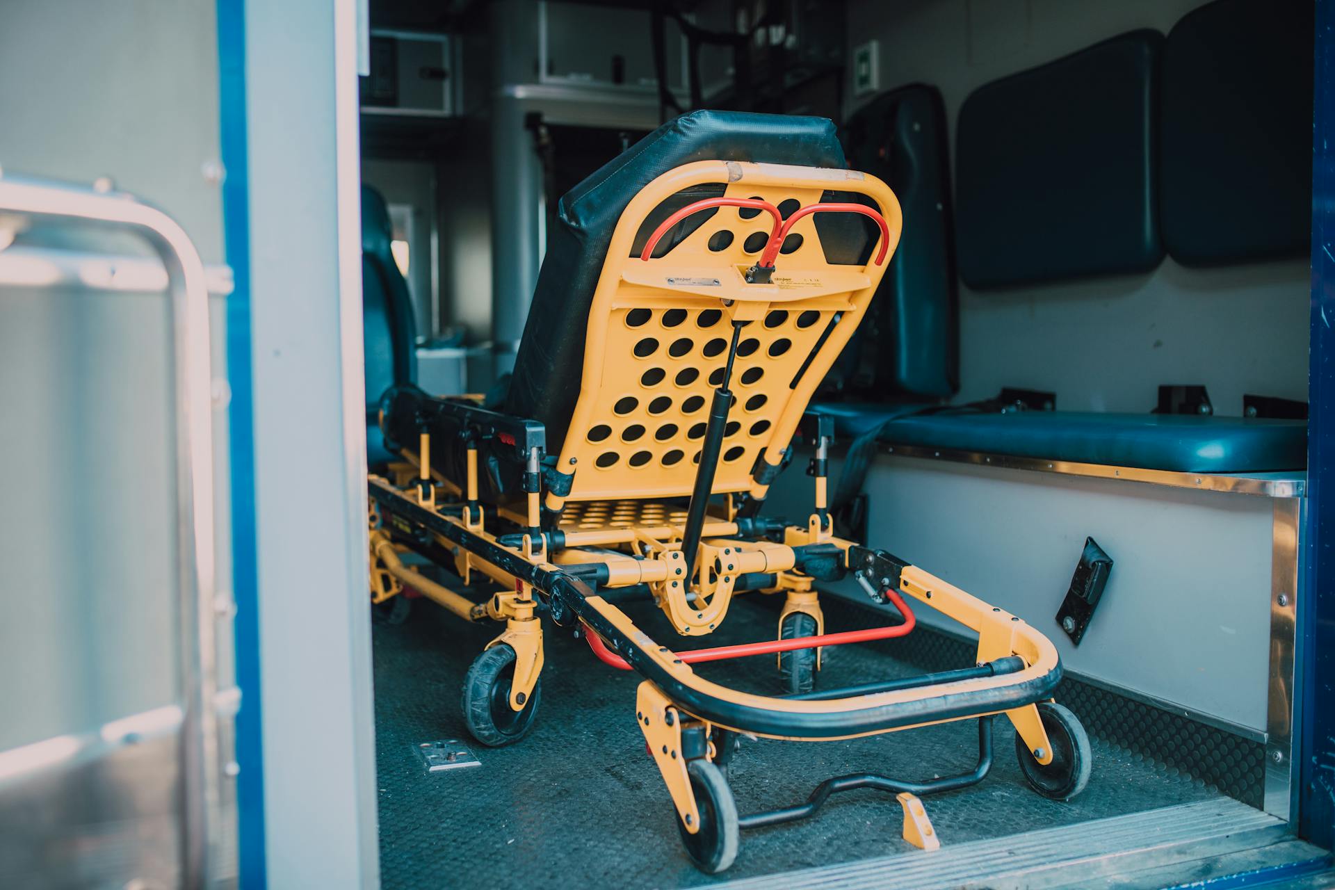 Inside view of an ambulance showing a yellow stretcher with black padding